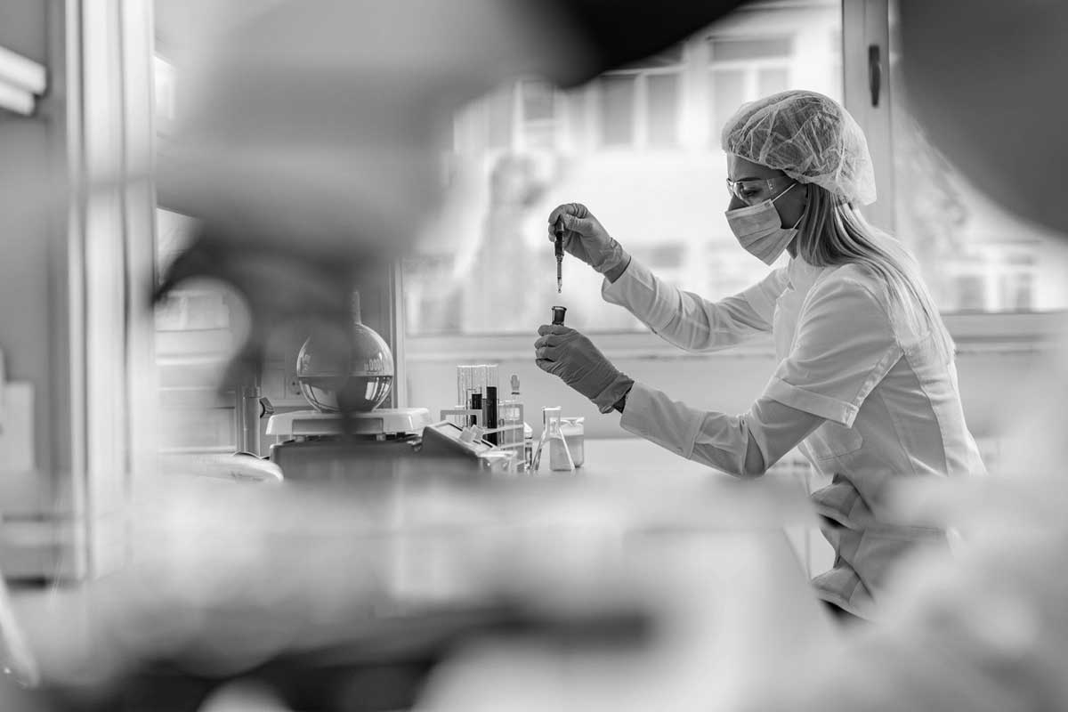 Young female chemist working with liquid in a laboratory